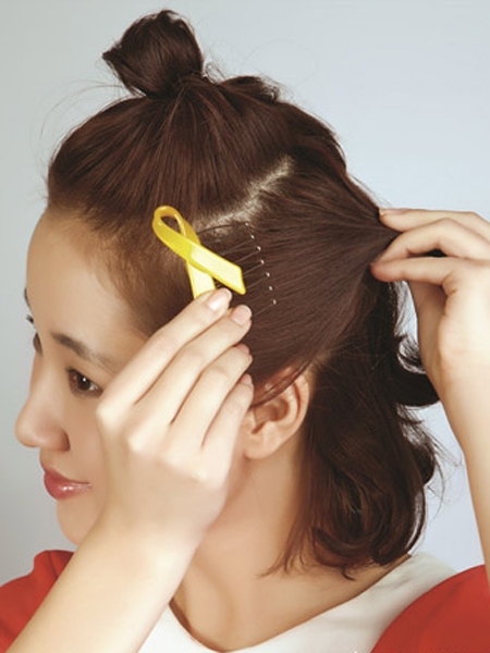 step3:取出左侧耳朵附近的头发用发夹向脑后固定