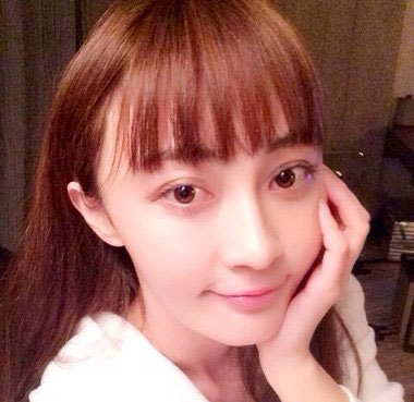 自拍照中的姚笛依旧梳着空气刘海中长直发发型,栗红色长直发从耳后