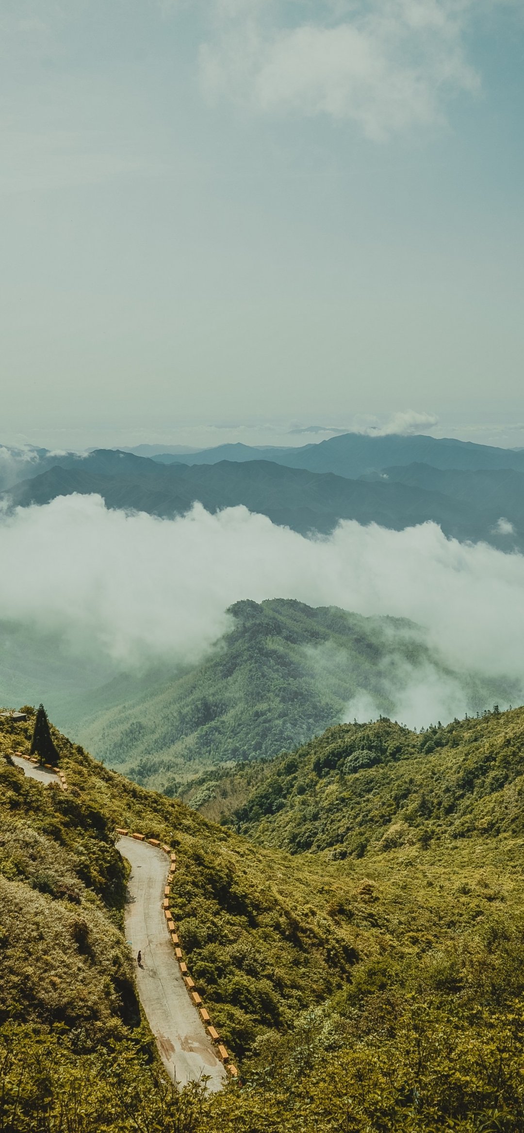 云海围绕的绿色大山大山间的公路风景