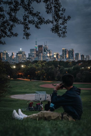 男人坐到草地看城市夜景图片